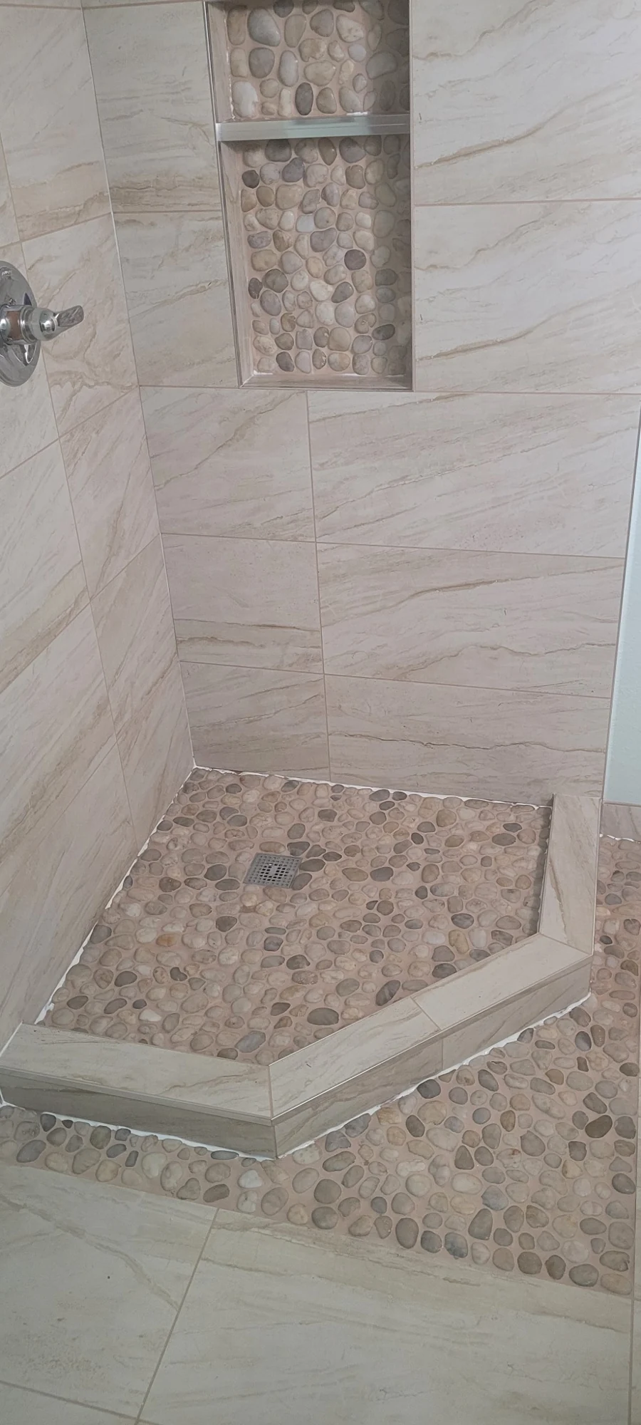 Custom shower with pebble floor and recessed niche