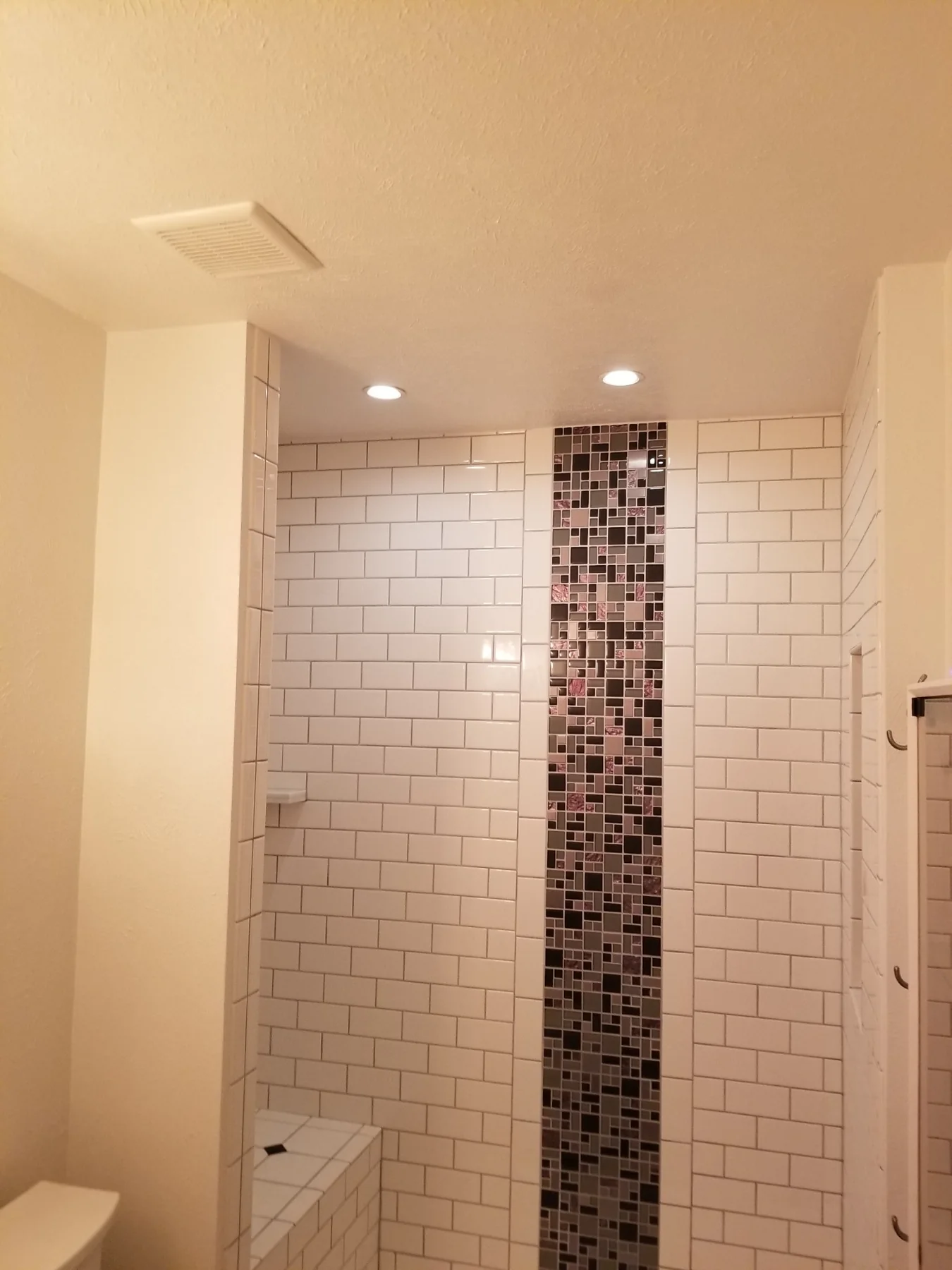 Custom tiled shower with decorative accent strip