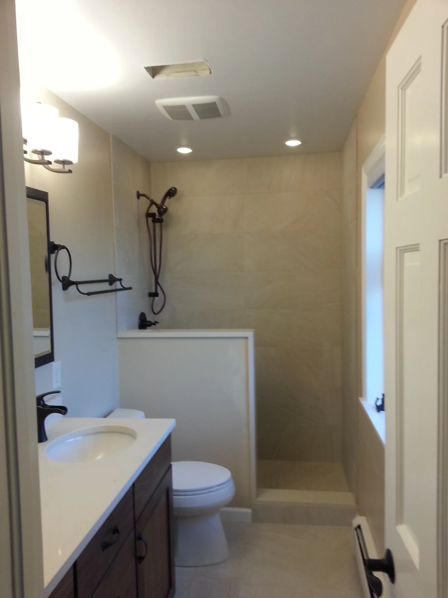 Walk-in shower bathroom remodel with dark fixtures and tiled walls