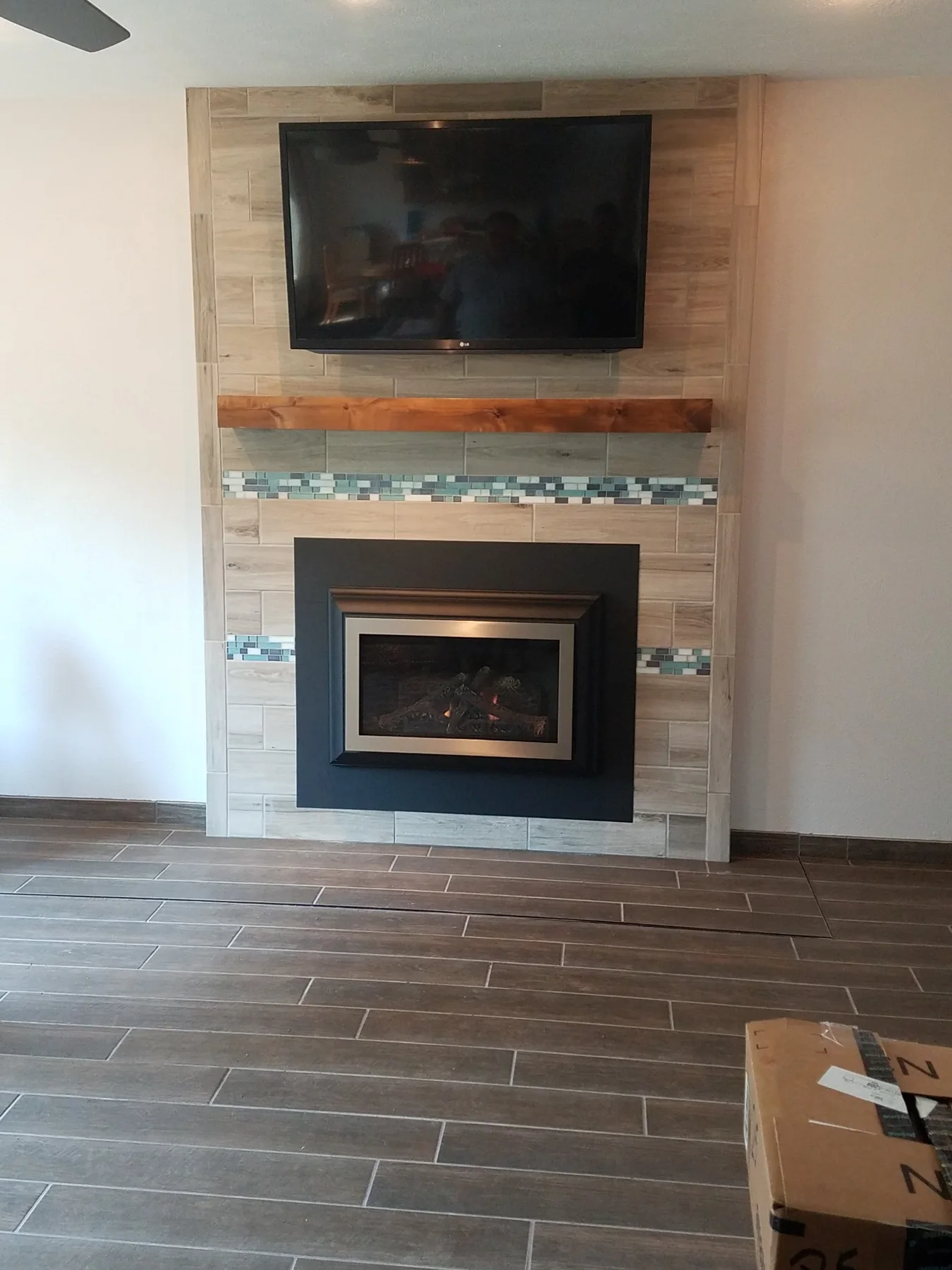 Custom tiled fireplace wall with wood mantel