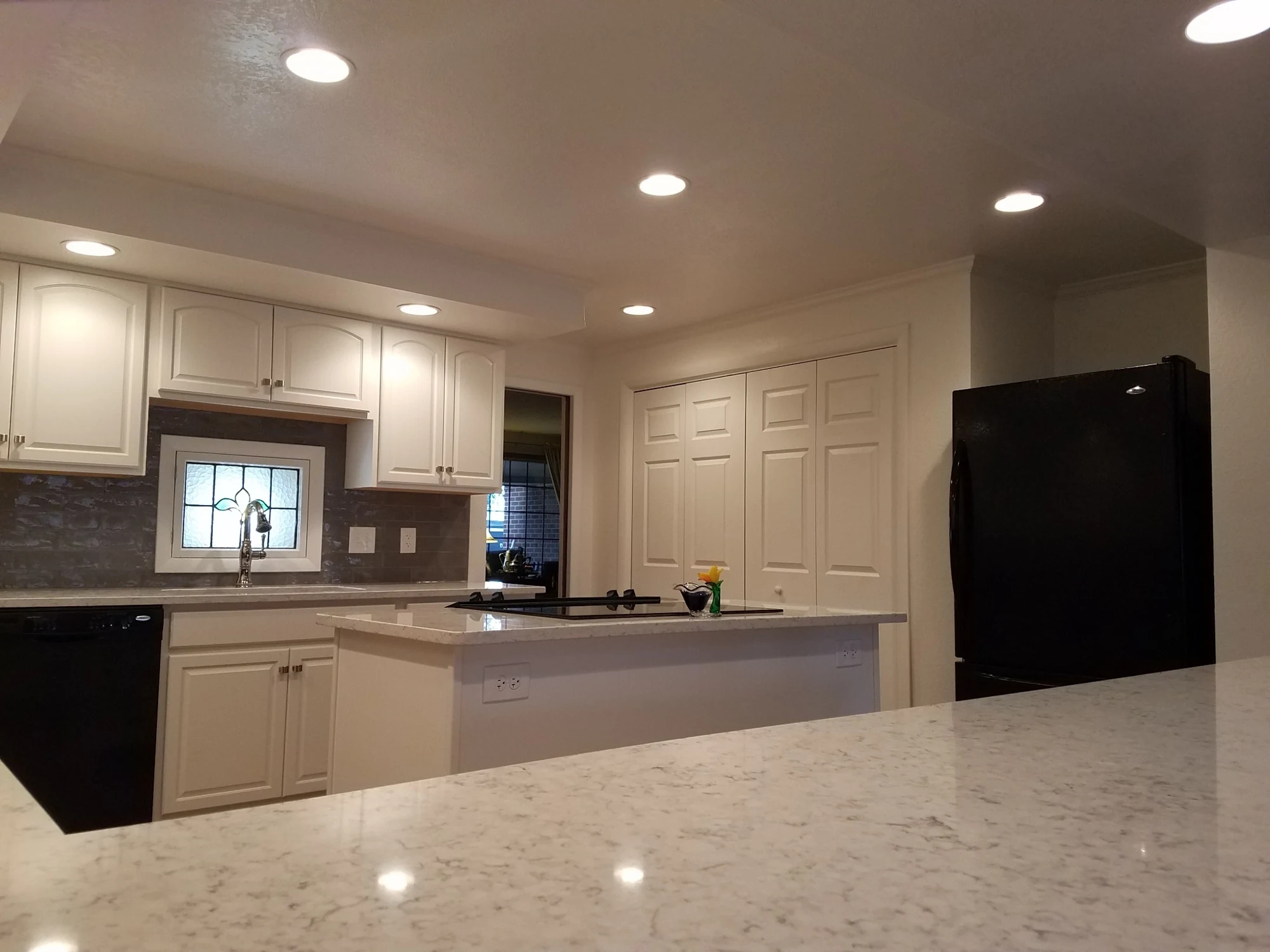 Remodeled white kitchen with quartz counters and island