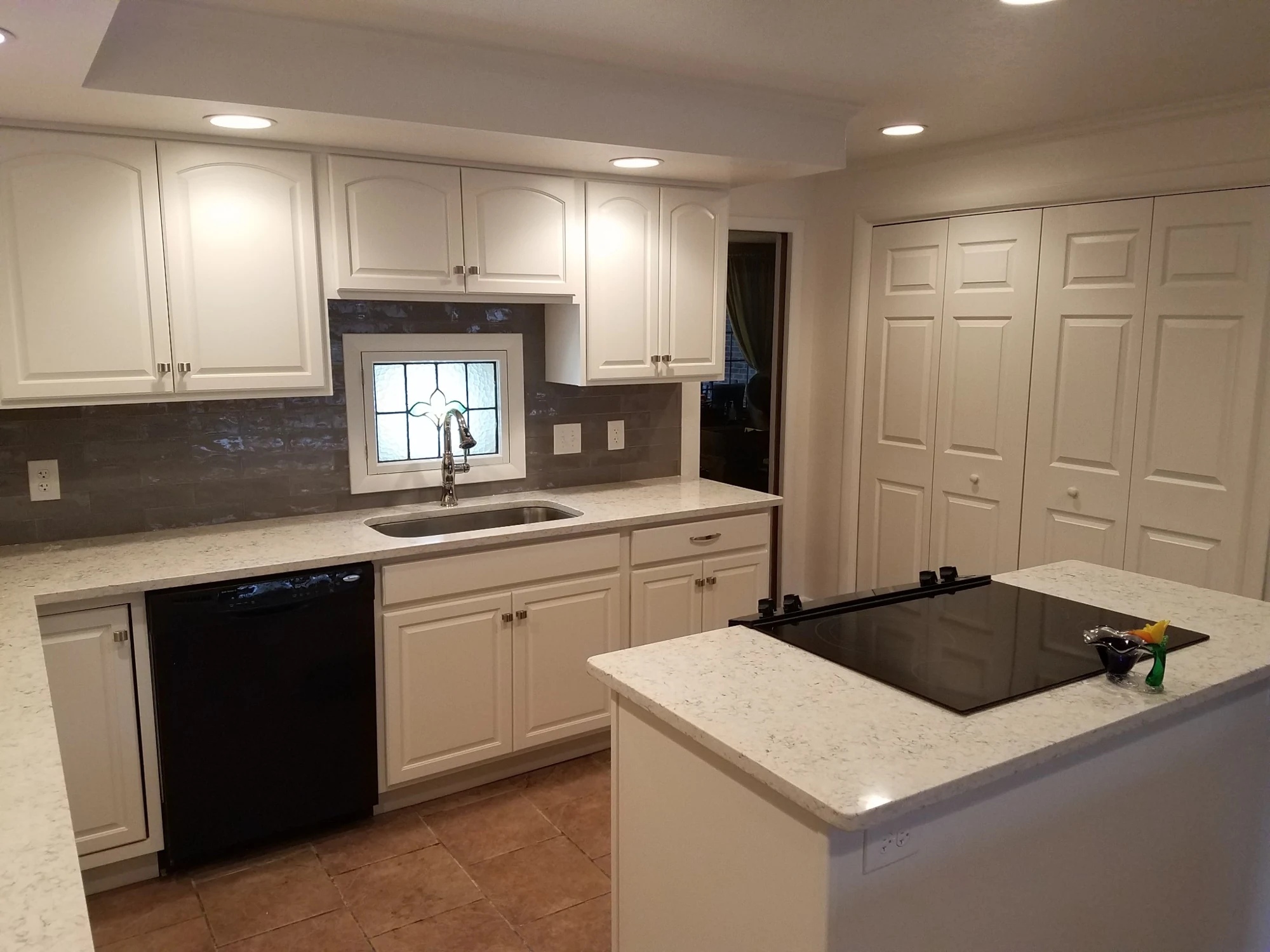 Kitchen sink wall, island cooktop and quartz counters